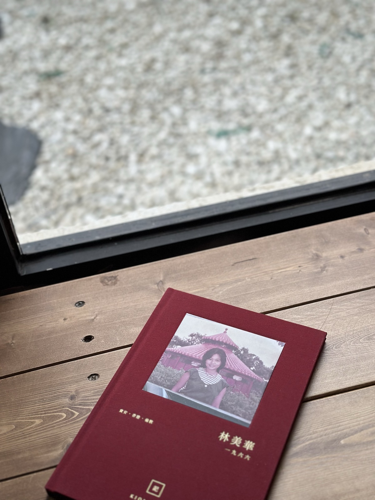 紅色布面燙金留聲書封面，內嵌長輩後生時嘅舊相同金色姓名年份，放喺木枱上