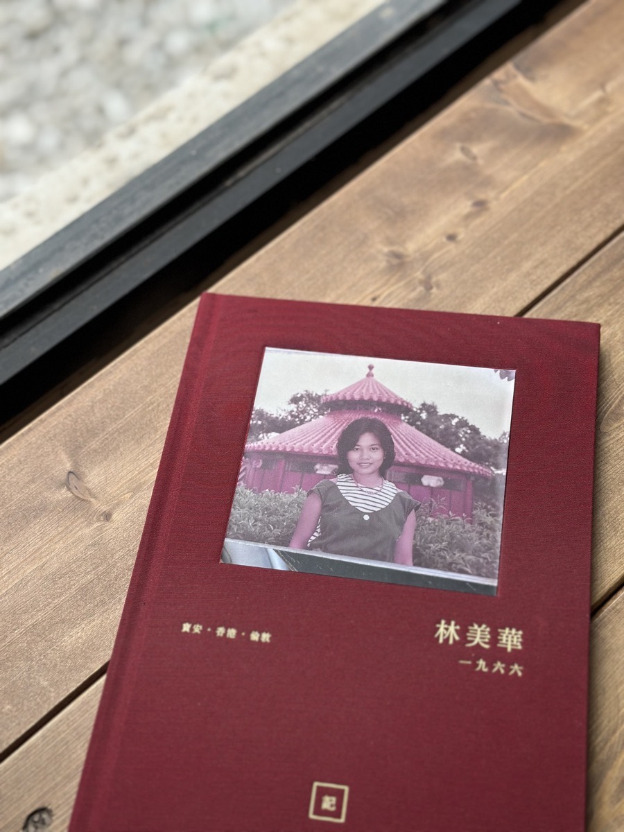 紅色布面燙金長輩故事書封面，內嵌長輩後生時嘅黑白舊相同金色姓名年份